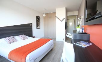 a bedroom with a bed , desk , and chairs , featuring an orange blanket and white walls at Adonis Paris Sud