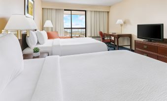 a hotel room with two beds , one on the left and one on the right side of the room at Courtyard Flint Grand Blanc