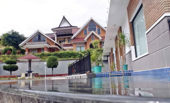 a modern house with a swimming pool and a water fountain in front of it at Khas Parapat