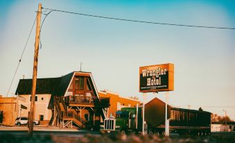 "a city street with a large wooden building and a sign that reads "" wrangler hotel .""." at Wrangler Inn Mobridge