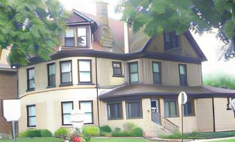 a large , two - story house with a brown roof and white walls is surrounded by trees at Barclay Bed and Breakfast