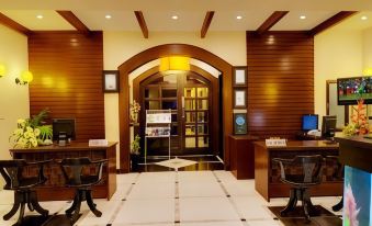 a hotel lobby with two reception desks , a wooden door , and a television mounted on the wall at The Richmond