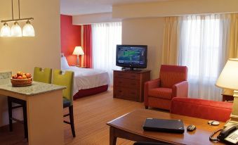 a hotel room with a bed , a television , and a desk with a laptop on it at Residence Inn Hartford Avon