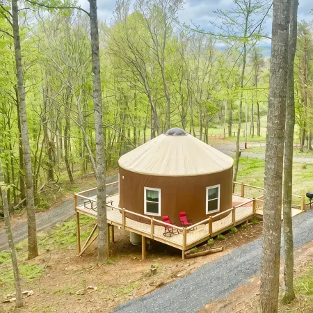 Elevated eclectic yurt with wrap-around porch, hot tub, and mountain view!