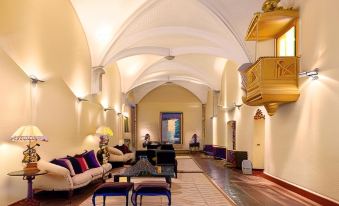 a spacious living room with a large flat - screen tv mounted on the wall , surrounded by couches and chairs at Convento do Espinheiro, Historic Hotel & Spa