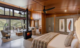 a modern bedroom with a large bed and a fire place , creating a cozy atmosphere at Spicers Sangoma Retreat