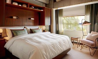 a large bed with white sheets and pillows is in a room with wooden furniture at Ellery Beach House