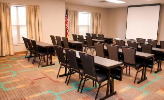 a large conference room with rows of chairs arranged in a semicircle , ready for a meeting at Residence Inn Cincinnati Airport