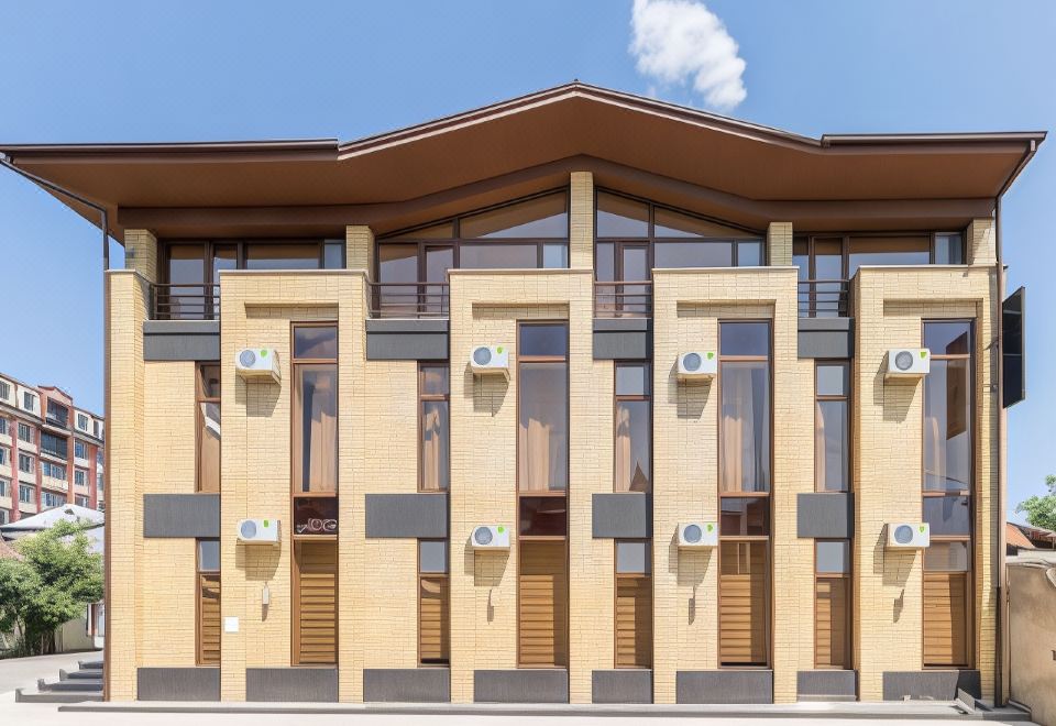 a modern building with yellow and black walls , brown roof , and multiple air conditioning units at Orion Hotel