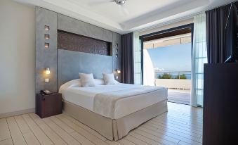 a large bedroom with a king - sized bed and a view of the ocean through a window at Te Moana Tahiti Resort