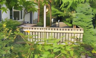 a backyard with a wooden deck , surrounded by lush greenery and a pond , providing a serene and natural environment at Cwmbach Guest House