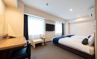 a hotel room with a large bed , a desk , and a tv . the room is clean and well - organized at Just Inn Matsusaka Station