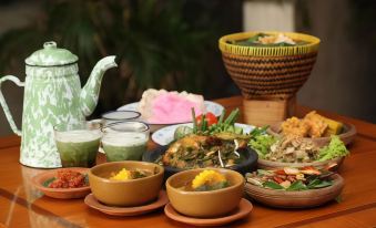 a dining table with a variety of food items , including bowls and plates filled with various dishes at Grand Pasundan Convention Hotel