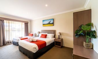 a hotel room with two beds , one on the left side and another on the right side of the room at Parkes International