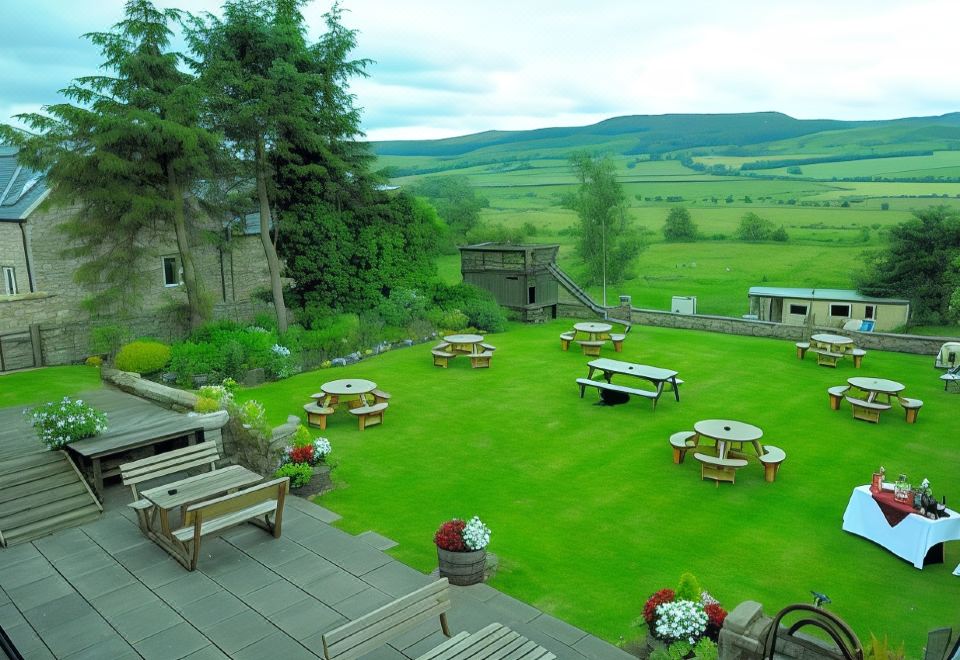 a large grassy area with several picnic tables and benches , providing a pleasant outdoor dining experience at Three Wheat Heads