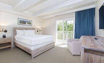 a modern bedroom with white walls , wooden furniture , and blue curtains , including a bed and couch at Legacy Vacation Resorts-Indian Shores