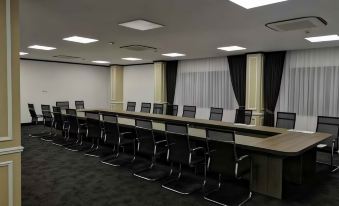 The conference room is spacious and equipped with long tables and chairs, arranged in the middle and facing an empty area at Aaron Vientiane Hotel