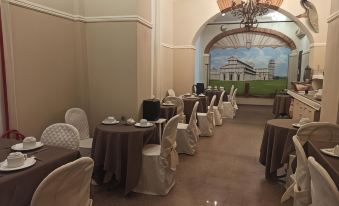 a dining room with tables and chairs set up for a formal event , possibly a wedding reception at Hotel Leonardo