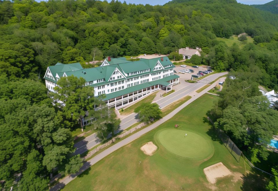 aerial view of a large building with a green roof , surrounded by trees and grass at Eagle Mountain House and Golf Club