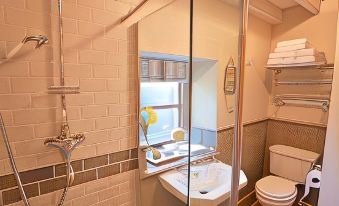 a small bathroom with a shower , toilet , and sink , as well as towels on the floor at Grove Park
