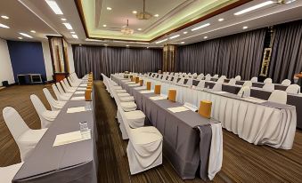 a conference room set up for a meeting , with tables and chairs arranged in rows at Blu Hotel