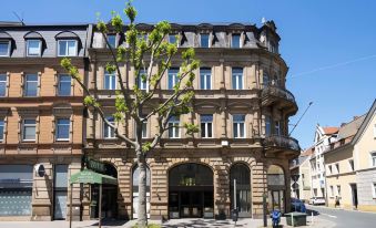 a large , curved building with a tree in front and an awning on the street below at Hotel National