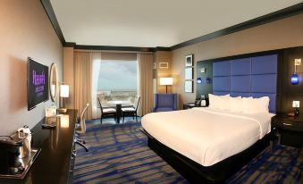 a modern hotel room with a large window , blue carpet , and white bed , along with other furniture and amenities at Harrah's Ak-Chin Casino Resort
