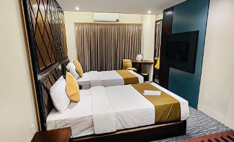 a modern hotel room with two beds , a tv , and a balcony , all decorated in white and gold colors at Richmond Hotel Sylhet