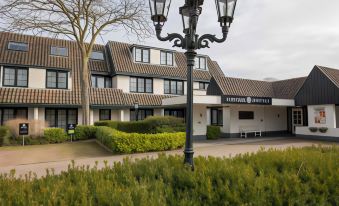 "a street lamp is in front of a building with the sign "" riverbank "" on it" at Fletcher Hotel-Restaurant de Klepperman
