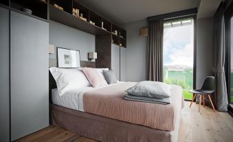 a modern bedroom with a large bed , a window , and a closet , all decorated in neutral colors at Arborina Relais