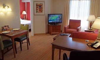a living room with a television , chairs , and tables is shown in the image at Residence Inn Hartford Avon