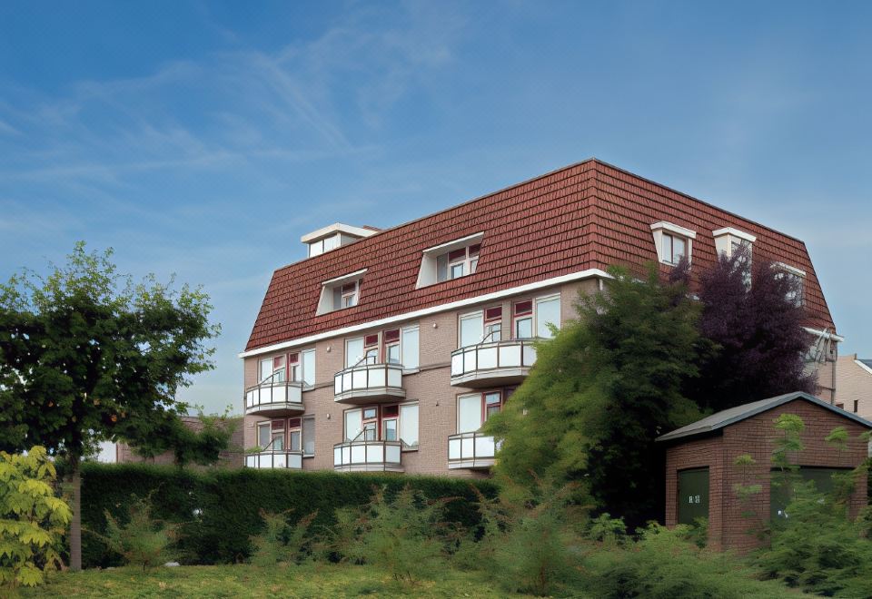 a modern building with a red roof , white balconies , and green plants under a clear blue sky at Fletcher Hotel Restaurant de Gelderse Poort