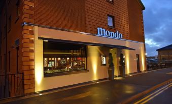 "a storefront with the name "" mondo "" in blue lights above a sign and a small window" at Mondo Hotel