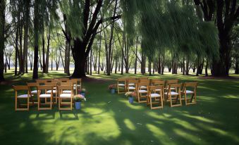 a wedding ceremony is taking place in a park , with rows of chairs set up for guests at Moruya Motel