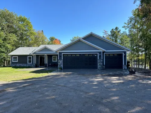 BEAUTIFUL lake front home with a private beach, dock and large yard