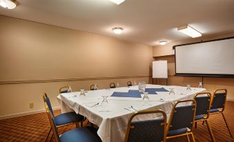 a conference room set up for a meeting with a long table , chairs , and wine glasses at Clarion Inn Falls Church- Arlington