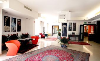 a modern living room with a red carpet , white walls , and various pieces of furniture at Best Western Cesena Hotel