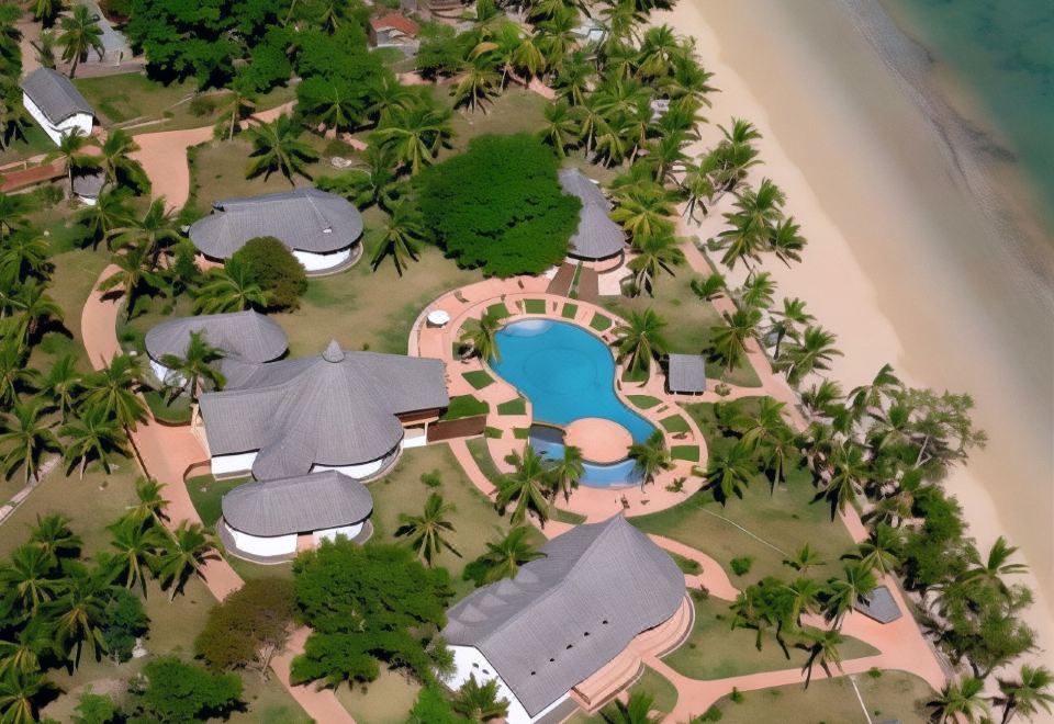 aerial view of a resort with multiple buildings , swimming pools , and palm trees near the beach at VOI Amarina Resort