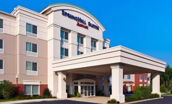 a large white building with a red awning , possibly a hotel or an office building at SpringHill Suites Long Island Brookhaven