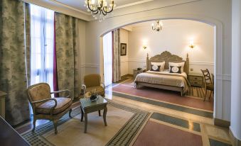 a luxurious bedroom with a large bed , two chairs , and a rug on the floor at Majestic Hotel