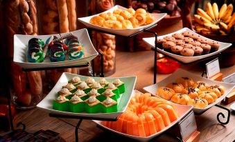 a variety of colorful desserts on display in a buffet setting , including cakes , cookies , and pastries at The Westlake Hotel & Resort Yogyakarta