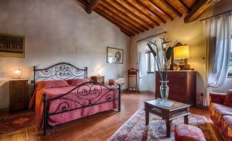 a spacious bedroom with a large bed , a fireplace , and a wooden ceiling beams on the ceiling at Villa Campestri Olive Oil Resort