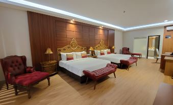 a hotel room with two beds , one on the left and one on the right side of the room at Ramada Suites by Wyndham Solo