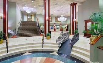 a hotel lobby with a staircase leading to the second floor , and a staircase in the background at Clayton Plaza Hotel & Extended Stay