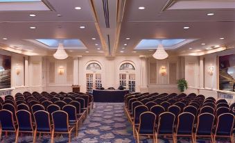 a large conference room with rows of chairs arranged in a semicircle , ready for a meeting at The Roslyn, Tapestry Collection by Hilton