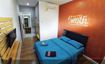 "a modern bedroom with blue bedding , wooden flooring , and an orange wall featuring the word "" breathe "" on it" at Bwalk Hotel Malang