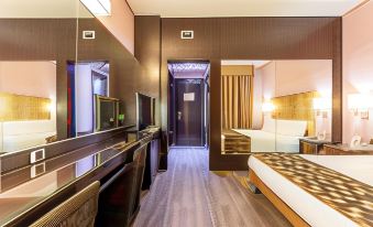 a hotel room with a king - sized bed , a flat - screen tv , and a bathroom with a toilet at Hotel Nord