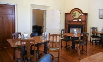 a dining room with wooden tables and chairs arranged for a group of people to sit and enjoy a meal at Left Bank