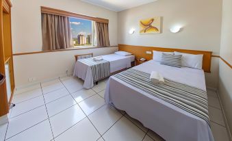 a hotel room with two beds , one on the left and one on the right side of the room at Hotel Nacional Inn Aracatuba