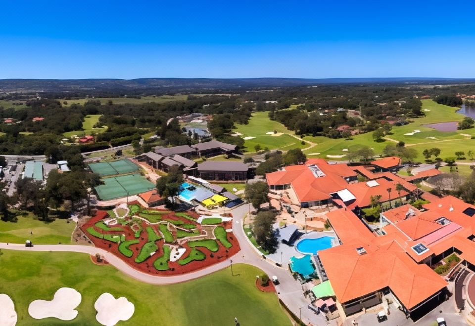 aerial view of a golf course with a variety of sports and recreational facilities , including tennis courts , golf courses , and golf at Novotel Swan Valley Vines Resort